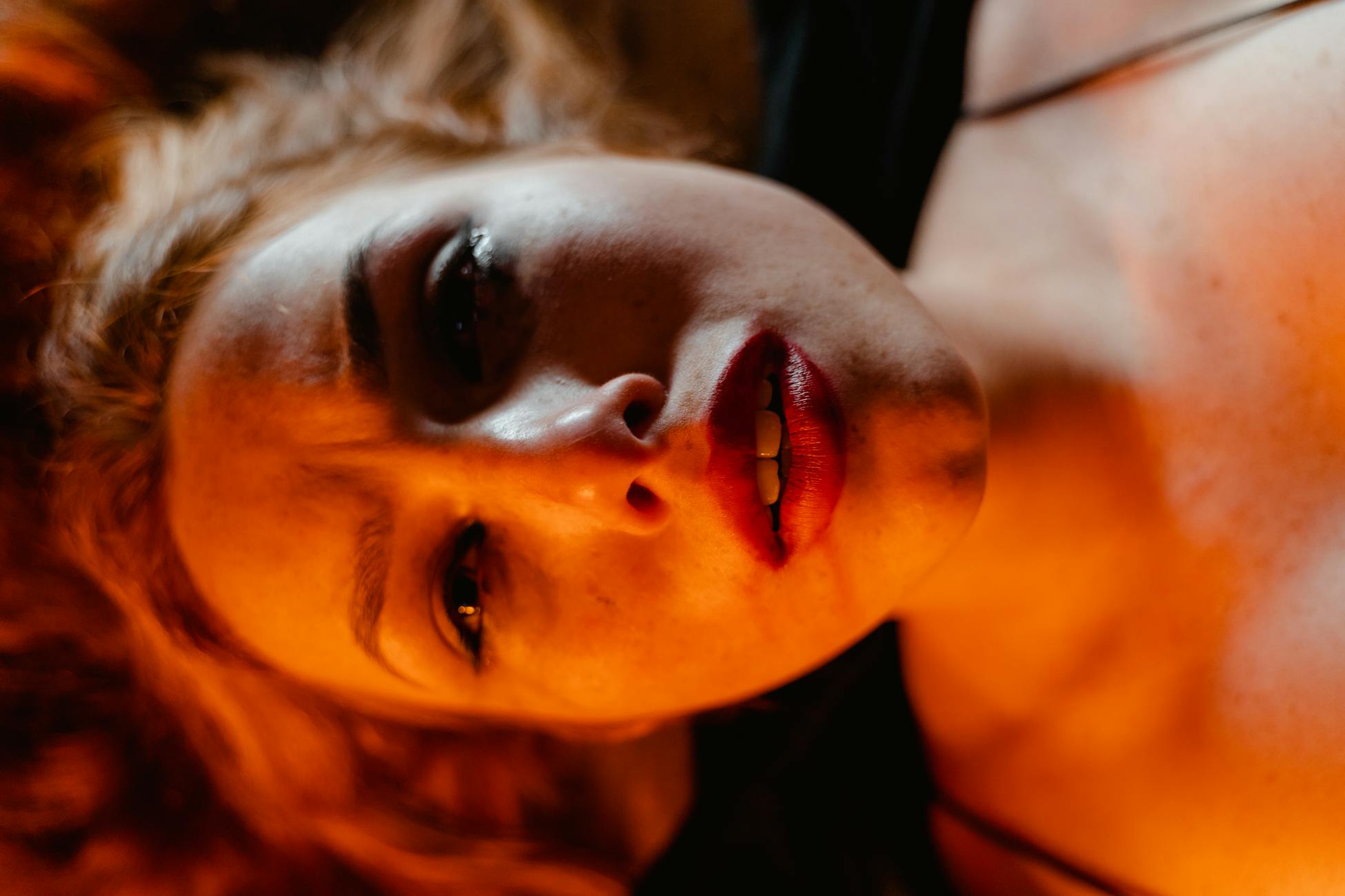 Close-up portrait of a woman with dramatic lighting, depicting intense emotion.