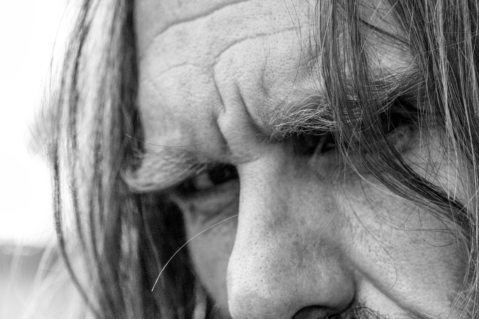 Close-up black and white photo capturing intense expression and detailed texture of man's face.