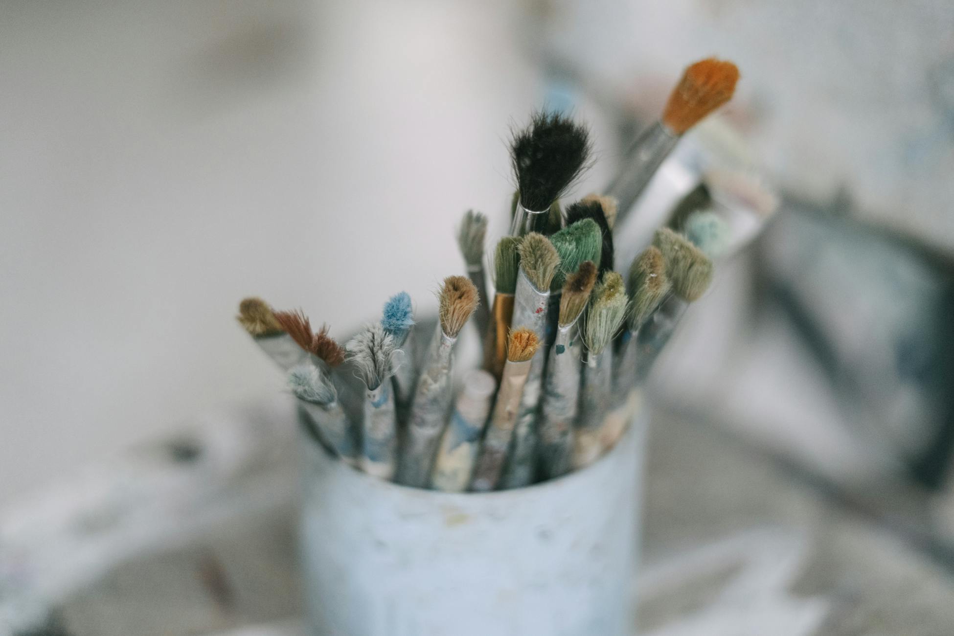 Assorted paintbrushes in a container for artistic creativity and painting.